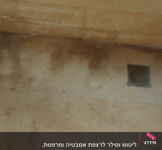 רצפה מלוכלכת עם כתמים כהים ליד אמבטיה